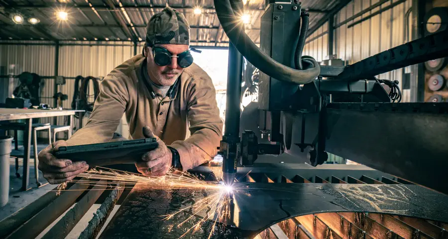 John Benedict at his plasma table, cutting a steel sheet in a shower of sparks